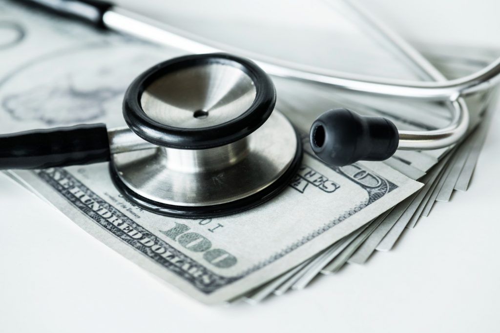 closeup-cash-stethoscope-healthcare-expenses-concept